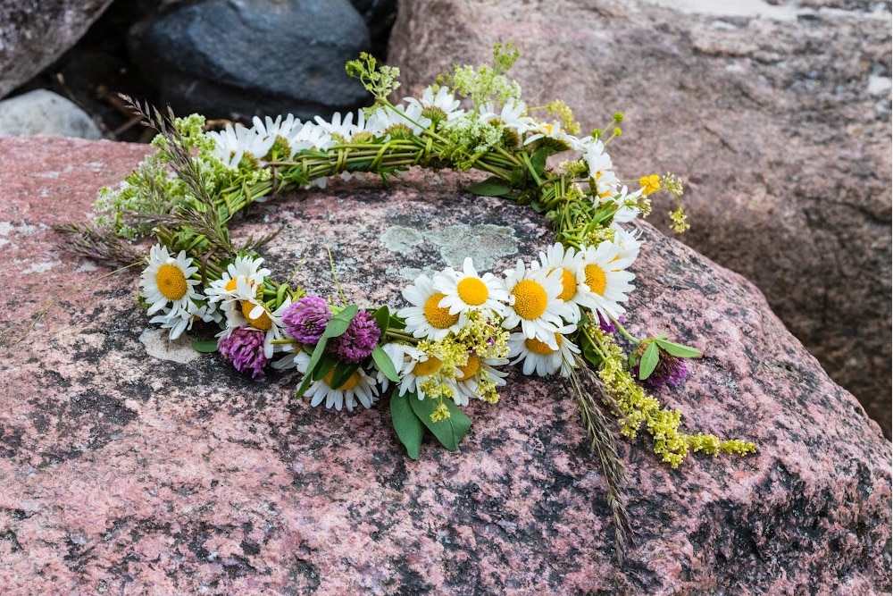 midsummer flower crown made of daisies, clover, and wildflowers on a boulder